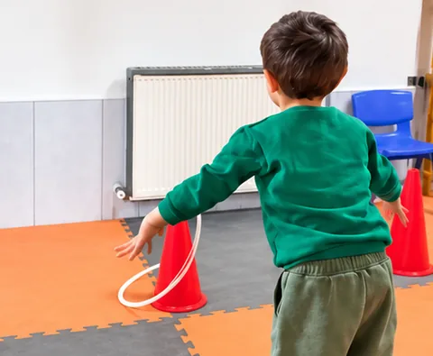 Çember ve dubalarla oynayan çocuk